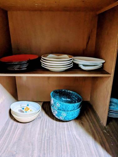 a wooden shelf with plates and bowls on it at Tsubame Sanjo Local Stay KYU in Sanjo