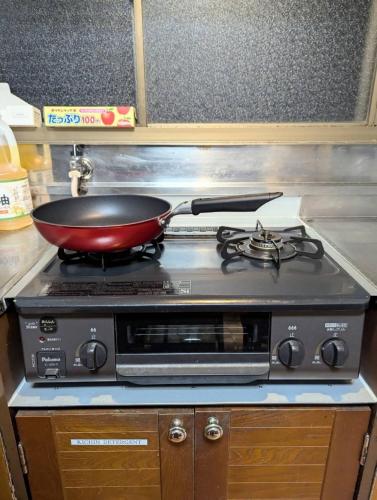 a pan on top of a stove in a kitchen at Tsubame Sanjo Local Stay KYU in Sanjo