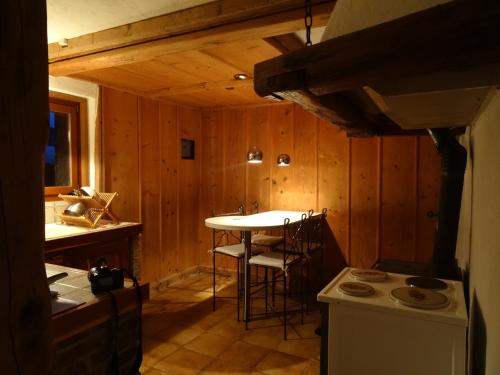 cocina con paredes de madera, mesa y fogones en Vire de Vie, en Villiers