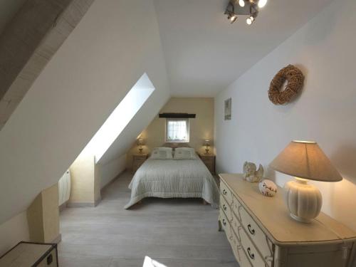 une chambre mansardée avec un lit et une fenêtre dans l'établissement Le bousquet, à Bars