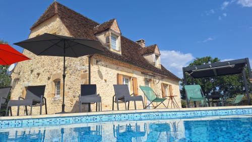 - un groupe de chaises et de parasols à côté d'une maison dans l'établissement Le bousquet, à Bars