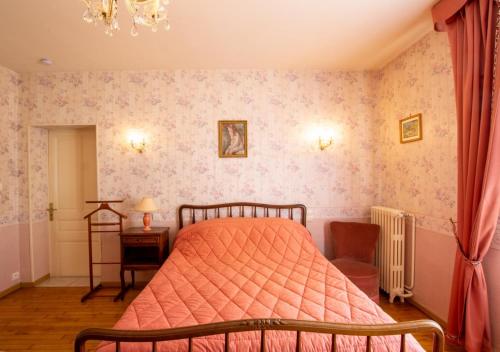 een slaapkamer met een bed met een oranje dekbed bij Petit gite in Cours-de-Pile