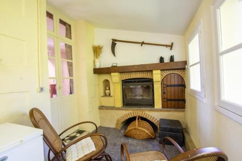 - un salon avec une cheminée, des chaises et une table dans l'établissement Petit gite, à Cours-de-Pile