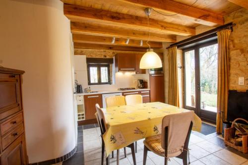 eine Küche und ein Esszimmer mit einem gelben Tisch und Stühlen in der Unterkunft Le coustal in Le Clapier