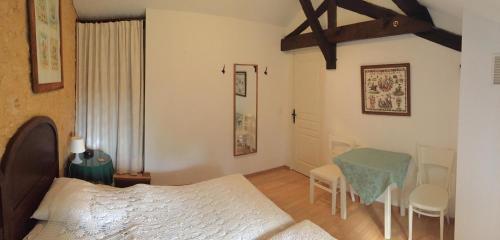 ein Schlafzimmer mit einem Bett, einem Tisch und Stühlen in der Unterkunft Le coustal in Le Clapier