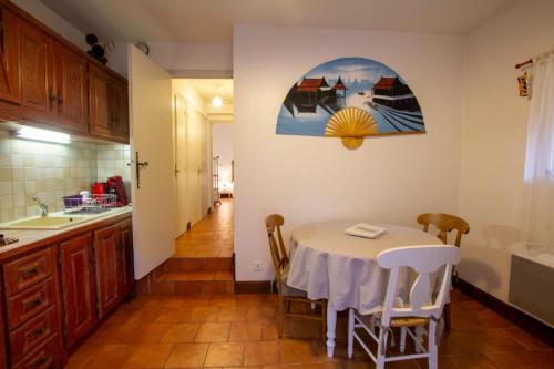 - une cuisine avec une table, des chaises et un évier dans l'établissement Gite bironais 