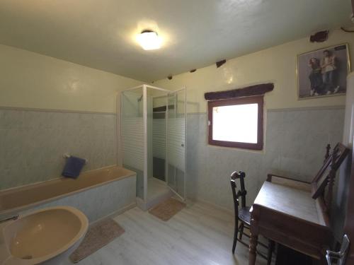 y baño con lavabo, ducha y mesa. en Lescurette, en Fossemagne