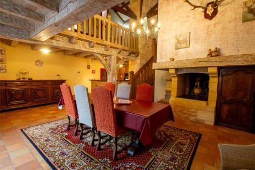 une salle à manger avec une table et des chaises et une cheminée dans l'établissement Gite bironais, à Biron