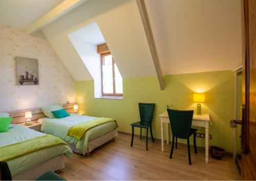 - une chambre avec 2 lits et un bureau avec des chaises dans l'établissement Le pech 4, à Badefols-sur-Dordogne