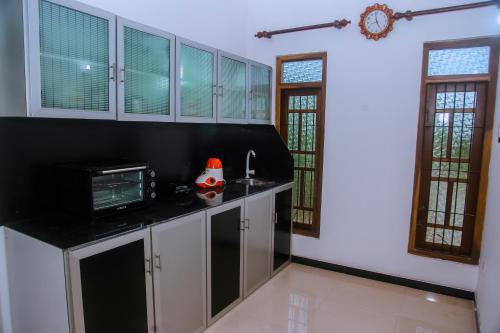 a kitchen with white cabinets and a microwave at Cradels Villa in Mirissa