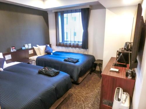 Postel nebo postele na pokoji v ubytování Natural Hot Spring Hotel Livemax Premium Hiroshima