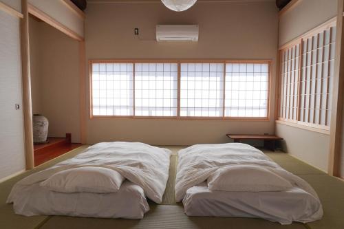 a large bed in a room with a large window at Kintsugi House Tajimi in Tajimi