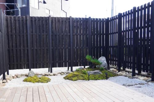 a garden with a black fence and a plant at Kintsugi House Tajimi in Tajimi