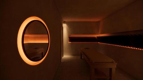 a bathroom with a mirror and a sink and a bench at La Gaia - Adult Only in Alanya