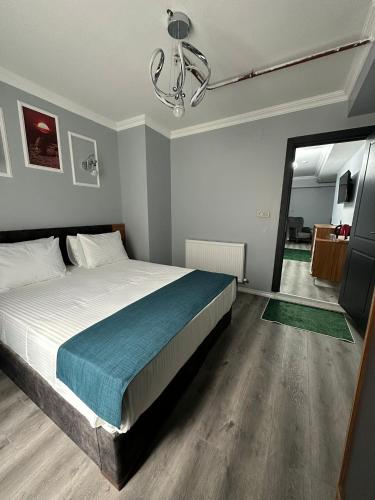 a bedroom with a large bed and a chandelier at Asgard Hotel in Beylikduzu