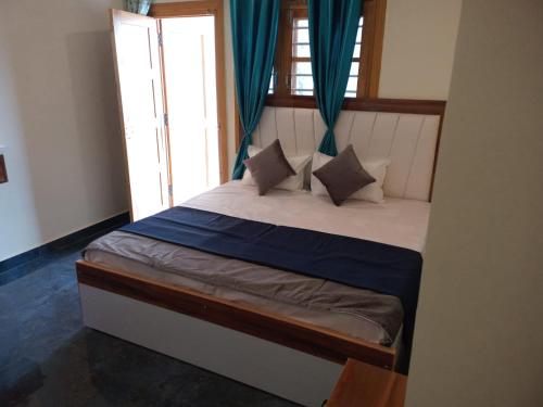 a bedroom with a bed with blue curtains at Jaiswal Home Stay in Rishīkesh