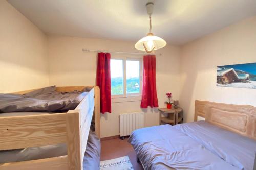 a bedroom with two beds and a window with red curtains at 06CM - Very nice T2 on the heights of Valberg in Péone