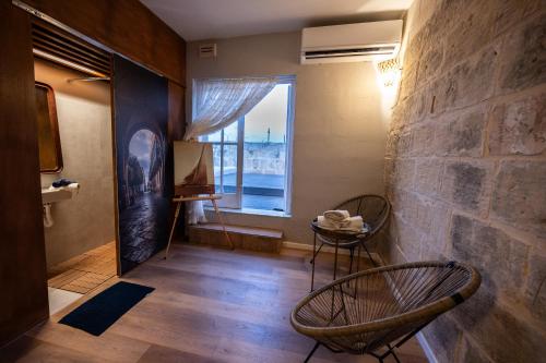 a room with two chairs and a large window at Grand Arcanum Apartment 2 - Comfortable and Elegant in Senglea