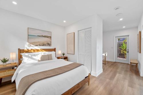 Habitación blanca con cama grande y suelo de madera. en 921 Apartment 4, en Fort Lauderdale