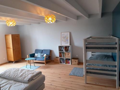 - une chambre avec des lits superposés et un canapé dans l'établissement Gîte de la Rogerie, à Blainville-sur-Mer