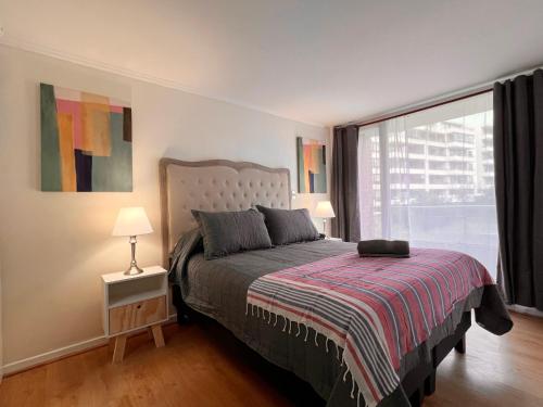 a bedroom with a bed and a large window at Hermoso departamento en parque urbano 1 in Concepción