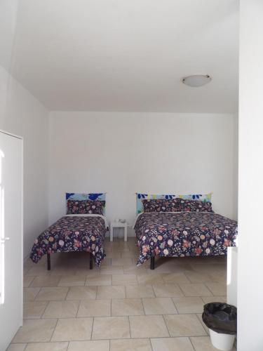 a room with two beds and a table at Affittacamere La Fortezza in Palmanova