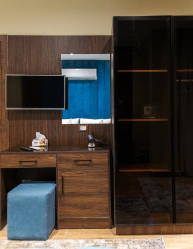 a room with a desk with a tv and a blue stool at Mirage pyramids view hotel in Cairo