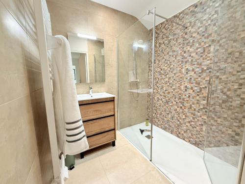 une salle de bain avec une douche en verre et un lavabo dans l'établissement Maison haut standing près de la plage, à Saint-Pierre-dʼOléron