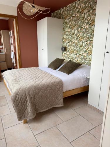 une chambre avec un grand lit et un mur dans l'établissement Appartement Port de Calais, à Calais