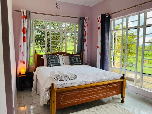 Un dormitorio con una cama y una ventana grande. en OlTepesi HomeStay, en Ololaimutiek