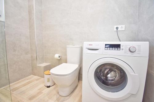 a bathroom with a toilet and a washing machine at Villa Caesar in Agios Ioannis