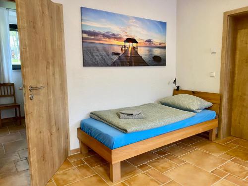 a bed in a room with a picture on the wall at Ferienwohnung auf dem Gutshof Renz in Weißenfels