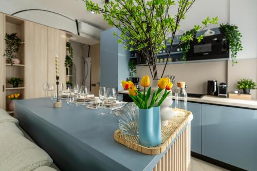 a table with a blue table cloth and flowers in a kitchen at AIASTAY Bucharest River Apartments in Bucharest