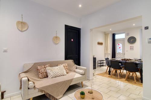 un salon avec un canapé et une salle à manger dans l'établissement Les Pivoines Magiques - Maison avec garage, à Marquise