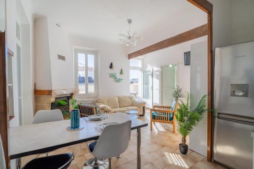 une cuisine et un salon avec une table et des chaises dans l'établissement Le Lamartine - Appt climatisé proche du port, à La Ciotat
