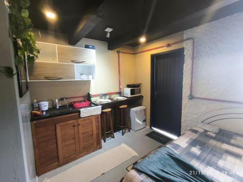 a small kitchen with a sink and a stove at Apartamento suíte com cozinha in Penha