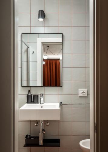 a bathroom with a sink and a mirror at BYPILLOW Goldoni in Florence