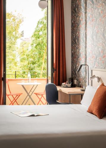 a bedroom with a bed and a desk and a window at BYPILLOW Goldoni in Florence