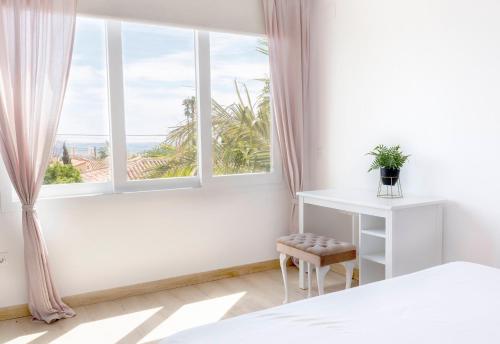 sypialnia z oknem ze stołem i krzesłem w obiekcie Villa Ana María w mieście Torremolinos