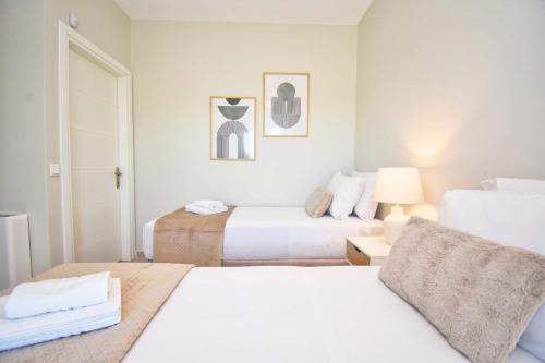 a white room with two beds and a lamp at Villa Caesar in Agios Ioannis