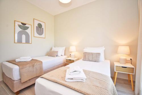 two beds in a small room with two lamps at Villa Caesar in Agios Ioannis