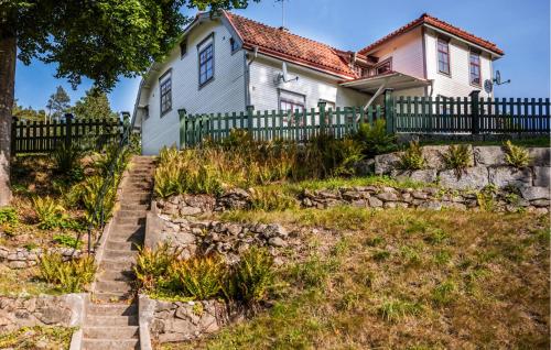 a white house with a fence and a stone wall at Beautiful Home In Svängsta With Sauna in Svängsta
