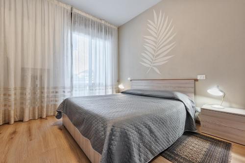 a bedroom with a bed and a large window at Mary Rose Apartment in Vicenza