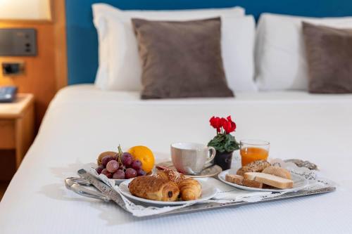 a tray of breakfast food on a bed at iH Hotels Milano Eur - Trezzano sul Naviglio in Trezzano sul Naviglio