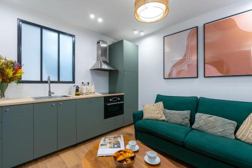 un salon avec un canapé vert et une cuisine dans l'établissement NEW - Designer Flat for 4 pp, à Paris