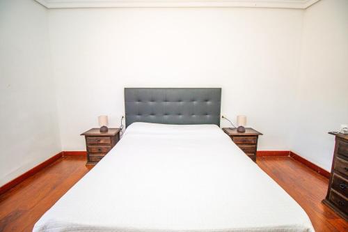 een slaapkamer met een groot bed met twee nachtkastjes bij Rentaliday Villa Alta in Tijoco de Abajo