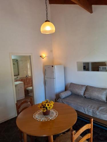 a living room with a table and a couch at Cabaña Olivia in Sierra de los Padres
