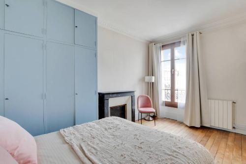 une chambre blanche avec un lit et une cheminée dans l'établissement Tour Eiffel - Saint Dominique - Invalides, à Paris