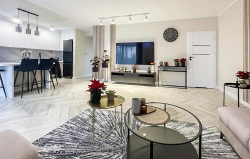 a living room with a couch and tables and a kitchen at Stunning Home In Kamien Pomorski in Kamień Pomorski