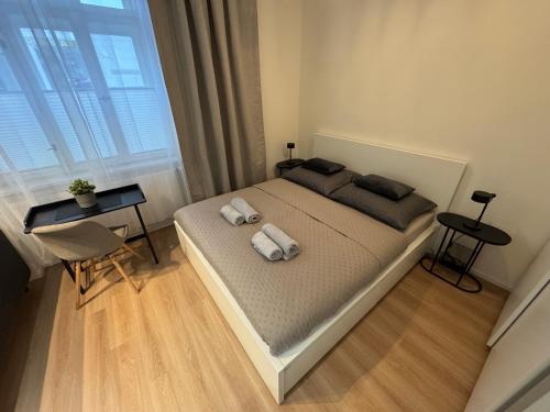 a bedroom with a bed with two towels on it at Karolinska Apartment City Center in Ostrava